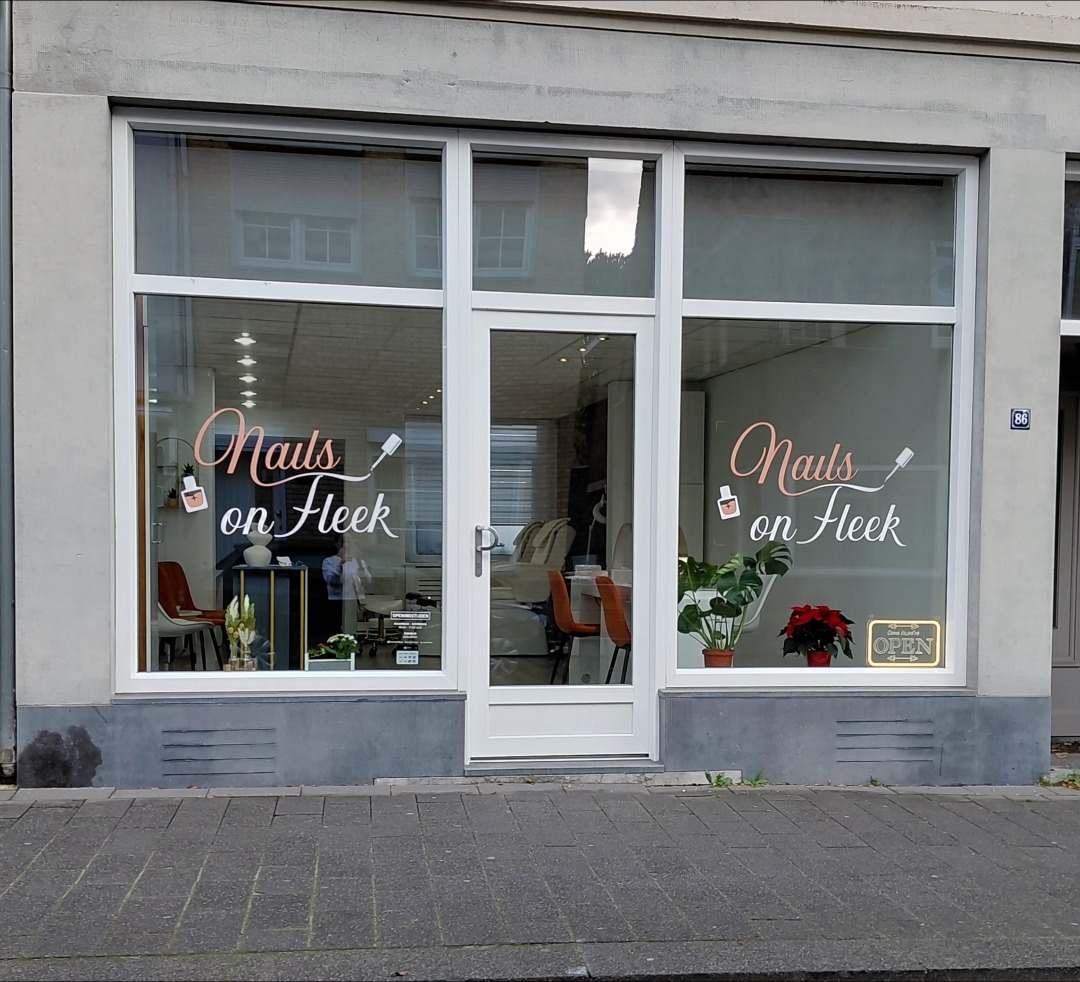 De salon van Nails on Fleek aan de Akerstraat 86 in Kerkrade, met de naam in schrijfletters op de etalage