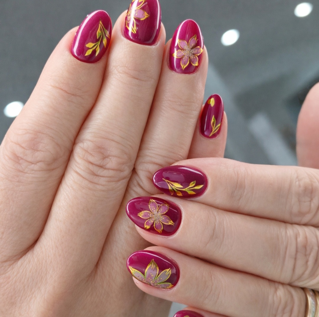 Bordeauxrode gelnagels met gouden bloemmotieven